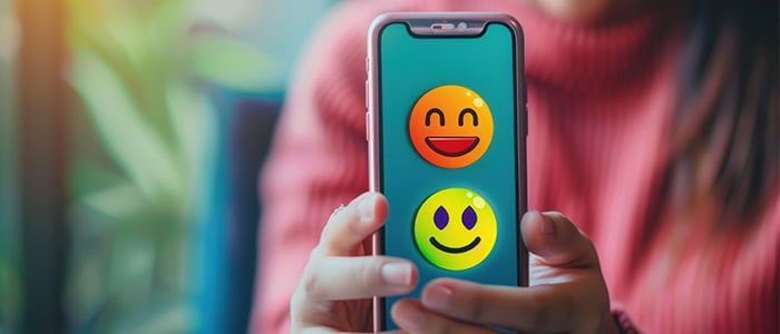 a woman showing a mobile phone with emojis displayed on the screen 