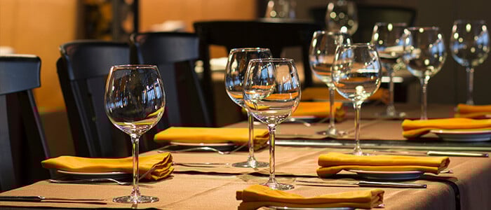 an elegant restaurant table featuring empty wine glasses and organized place settings, prepared for guests